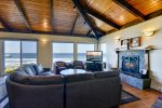 The living room offers comfortable furniture, a cozy fireplace and amazing views